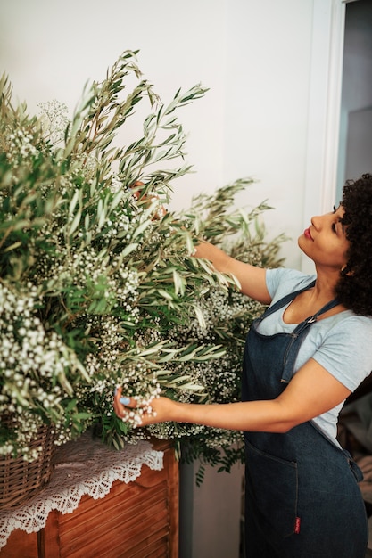 Florista feminina africana afro olhando flores