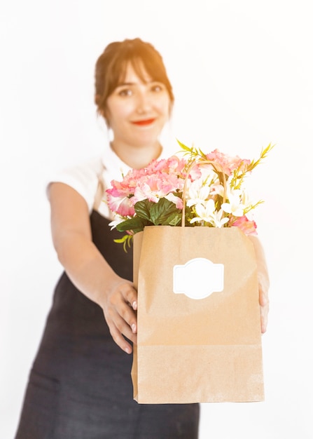 Florista feminina com saco de papel de flor no fundo branco