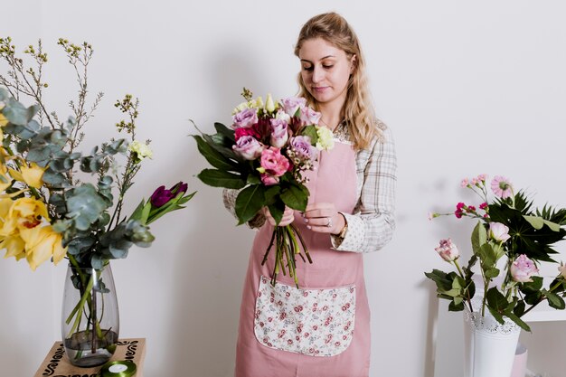 Florista no avental arrumando buquê