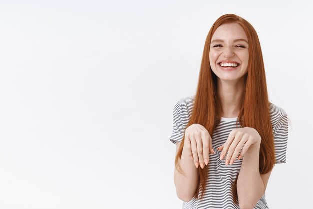 Fofa, adorável, atraente, ruiva, garota, brincar, levantar palmas, peito, cachorrinho, patas, rindo alegremente, imitando cachorro, curtindo passar o tempo amigos íntimos atitude alegre positiva, parede branca