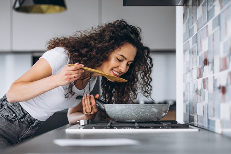 Foto grátis fogão de mulher fazendo macarrão na cozinha