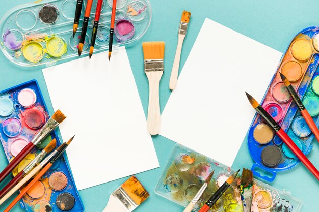 Foto grátis folha de papel e paleta de cores de pintura na mesa