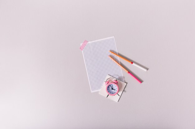 Folha de papel em branco colada com fita rosa na mesa