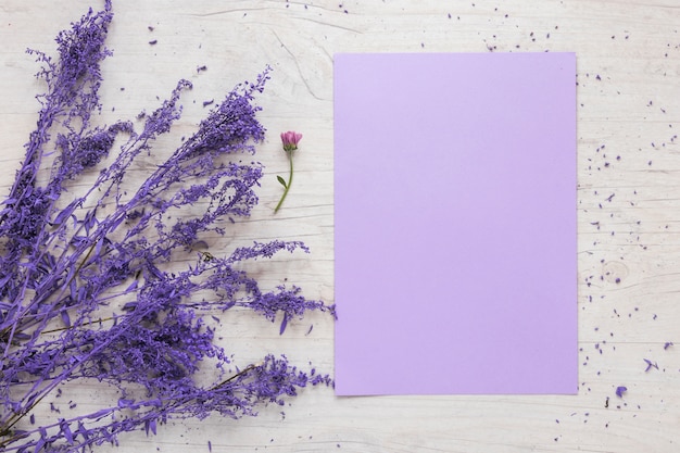 Foto grátis folha de papel em branco com ramos de flores na mesa