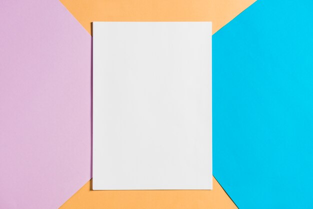 Folha de papel em branco no pano de fundo de papéis coloridos