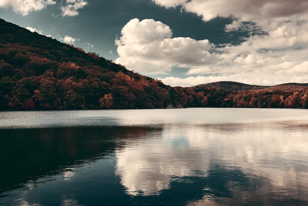 Folhagem colorida de outono com reflexo do lago.