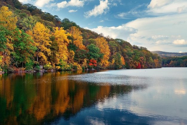 Folhagem colorida de outono com reflexo do lago.