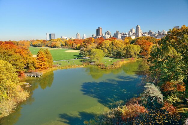 Folhagem de lago e outono com prédios de apartamentos no Central Park do centro de Manhattan New York City