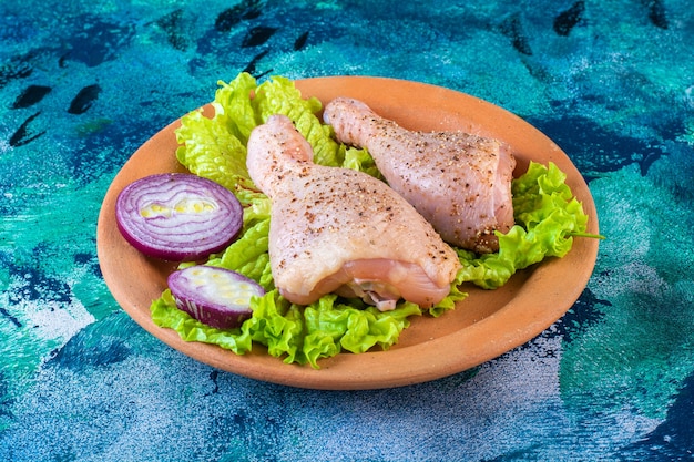 Foto grátis folhas de alface e cebola e coxinha de frango em um prato de barro