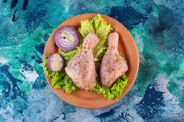 Folhas de alface e cebola e coxinha de frango em um prato de barro