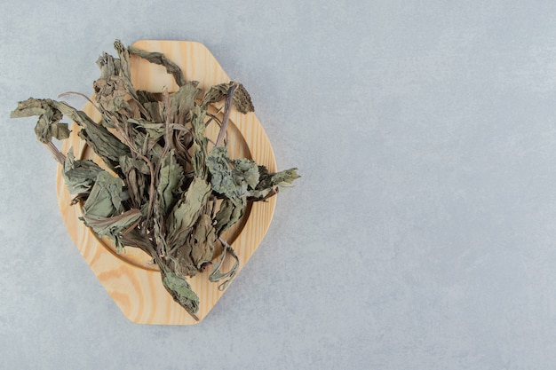 Folhas de chá secas na placa de madeira.