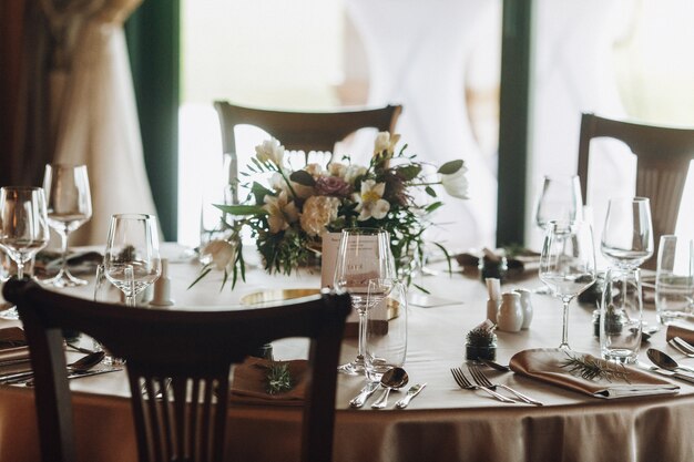 Folhas de pinheiro e buquê na mesa decorada com classe