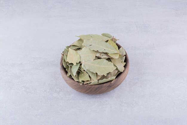 Folhas secas de louro verde em uma xícara rústica. Foto de alta qualidade