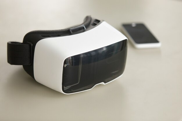 Fone de ouvido e smartphone VR na mesa, tecnologia móvel de realidade virtual
