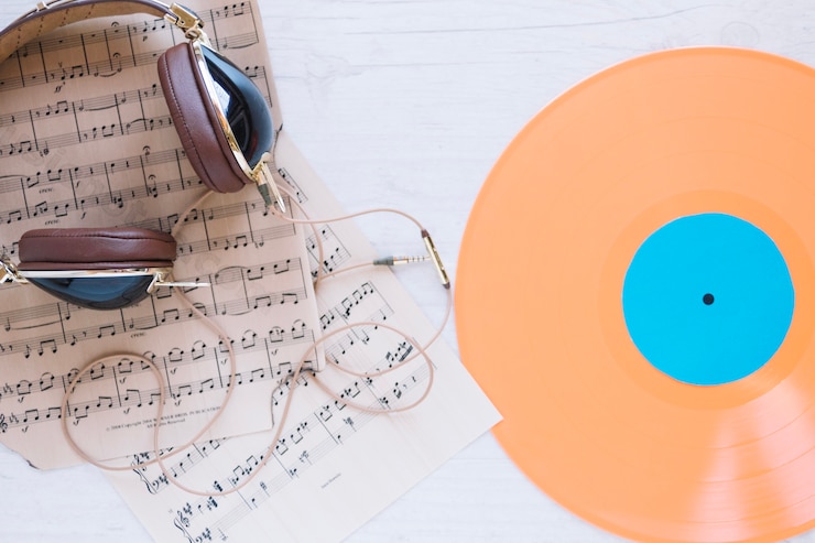Foto grátis fones de ouvido e partituras perto de discos de vinil