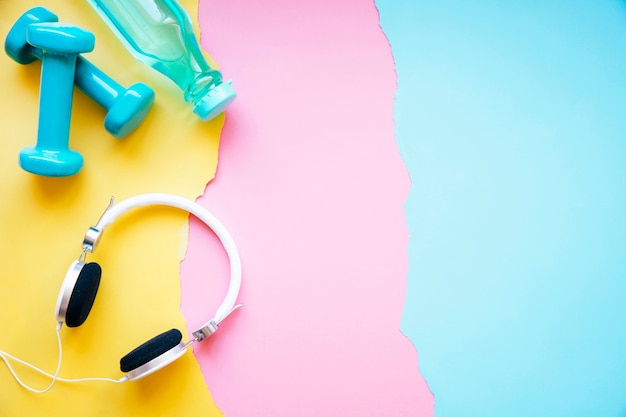 Foto grátis fones de ouvido perto de halteres e garrafas