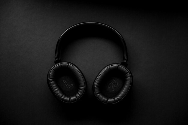 Fones de ouvido pretos e prateados na superfície preta