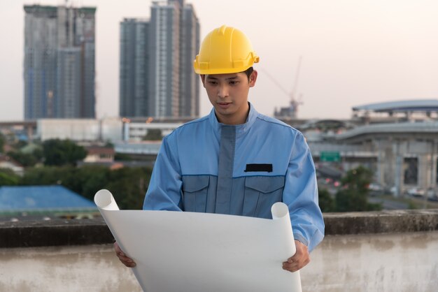 Foreman que olha o modelo em um local da construção