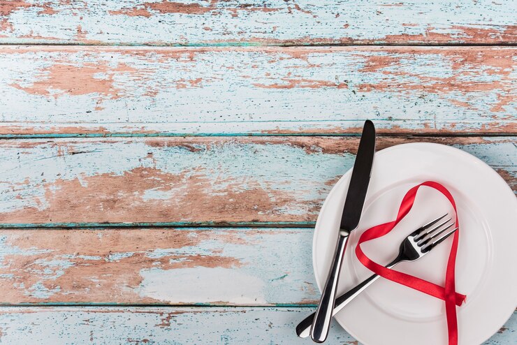 Foto grátis forma de coração da fita no prato com talheres na mesa