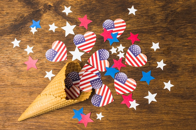 Forma de coração de bandeiras americanas EUA com estrelas derramadas de cone de waffle no cenário texturizado de madeira