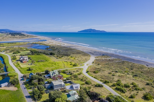 Foto aérea da praia de Otaki na Nova Zelândia, mostrando a ilha Kapiti à distância