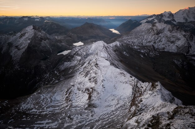 Foto aérea de montanhas nevadas com um céu claro