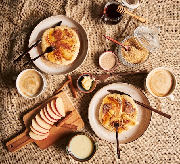 Foto aérea de panquecas de maçã, café, maçãs, mel e outros ingredientes de cozinha ao lado