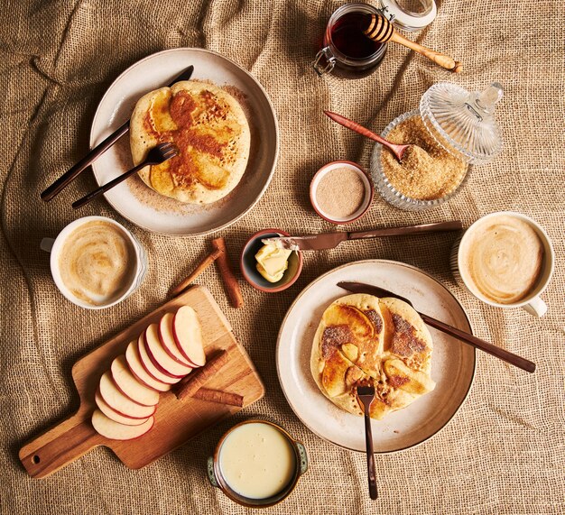 Foto aérea de panquecas de maçã, café, maçãs, mel e outros ingredientes de cozinha ao lado