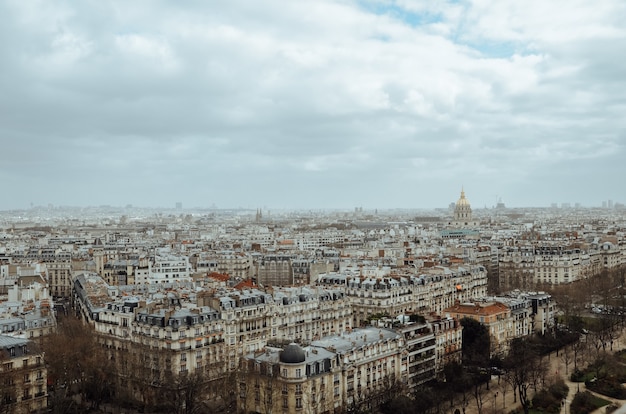 Foto aérea de Paris coberta de vegetação e edifícios sob um céu nublado na França