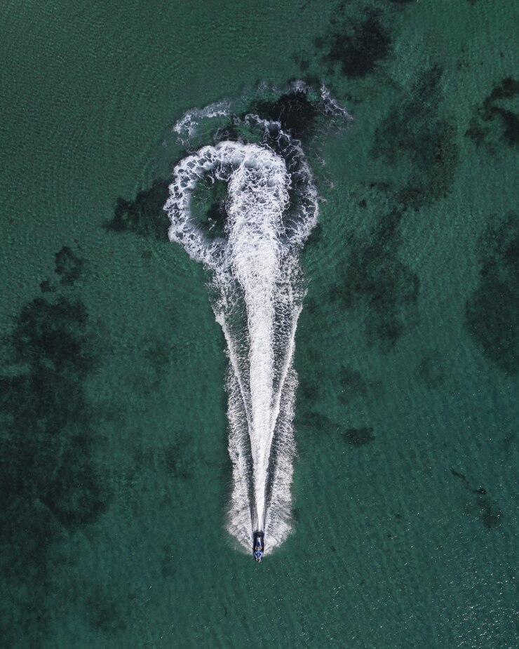 Foto grátis foto aérea de um iate de cruzeiro no mar deixando salpicos de vestígios