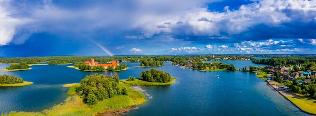 Foto aérea de um lago incrível cercado por florestas verdes e uma ilha com um antigo castelo