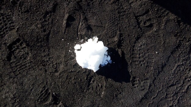 Foto aérea de um pouco de neve sobre o solo preto