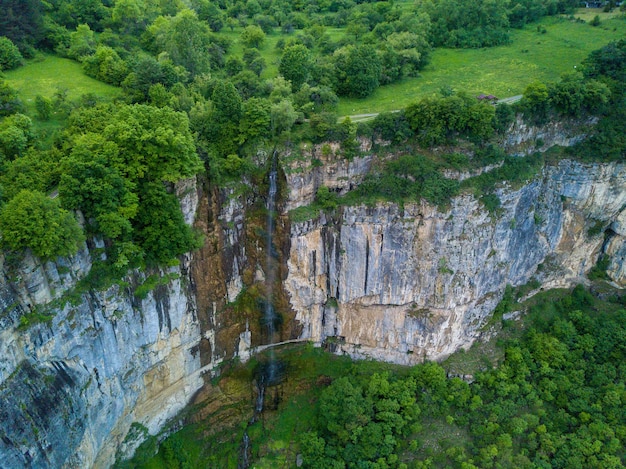 Foto aérea de uma cachoeira na bela montanha coberta de árvores
