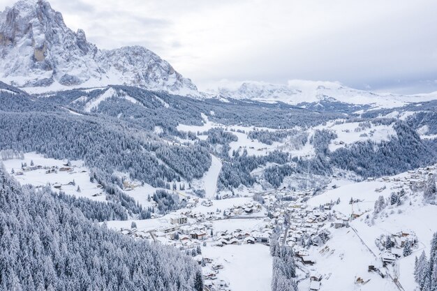 Foto aérea de uma cidade no inverno cercada por montanhas
