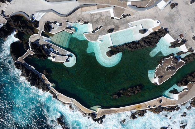 Foto aérea de uma grande piscina em um penhasco perto do mar