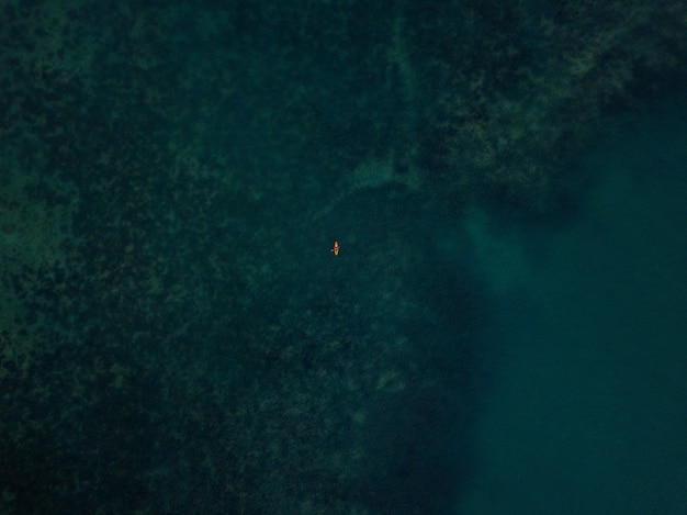 Foto grátis foto aérea do mar com um pequeno caiaque visível à distância