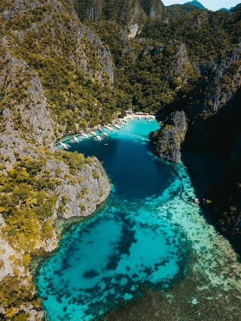 Foto aérea do oceano cercado por belas montanhas cobertas de verdes