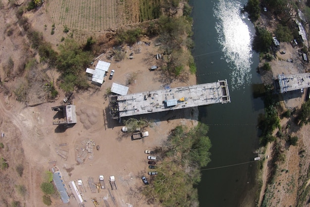 Foto aérea do processo de construção de uma ponte sobre um rio