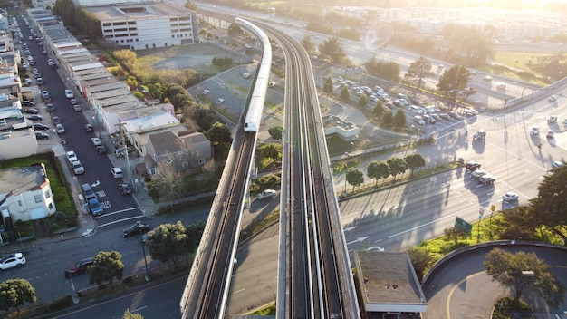 Foto aérea do trânsito rápido da área da baía de São Francisco, onde o trem se aproxima da estação Daly City,