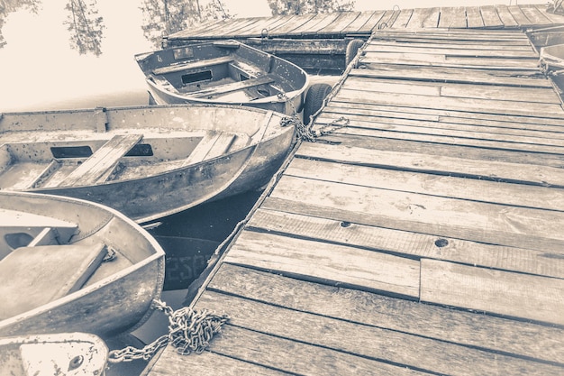Foto antiga do vintage. alguns barcos velhos e simples no cais de madeira Foto Premium