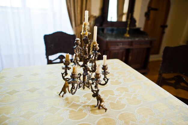 Foto aproximada de sofisticado candelabro dourado em cima da mesa