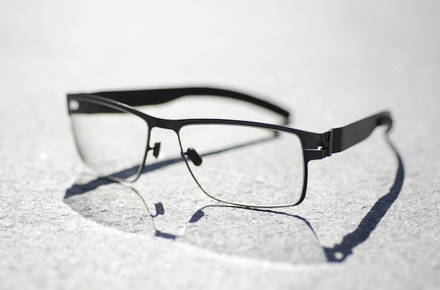 Foto aproximada de um par de óculos em uma superfície cinza