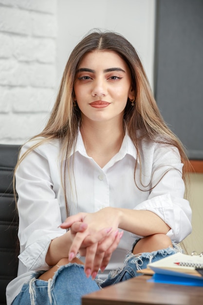 Foto aproximada de uma jovem sentada no escritório foto de alta qualidade