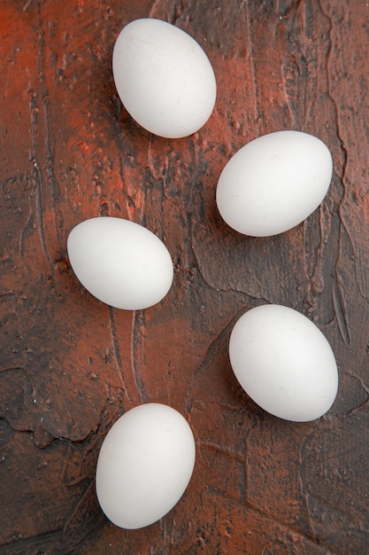 Foto colorida de ovos de galinha branca em mesa escura de comida de fazenda de comida de topo