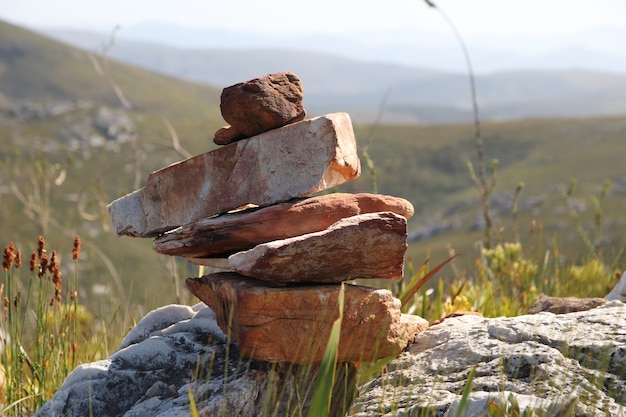 Foto grátis foto com foco seletivo de uma pilha de pedras nas colinas durante o dia