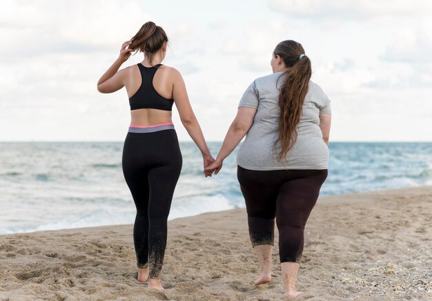 Foto completa amigos de mãos dadas na praia