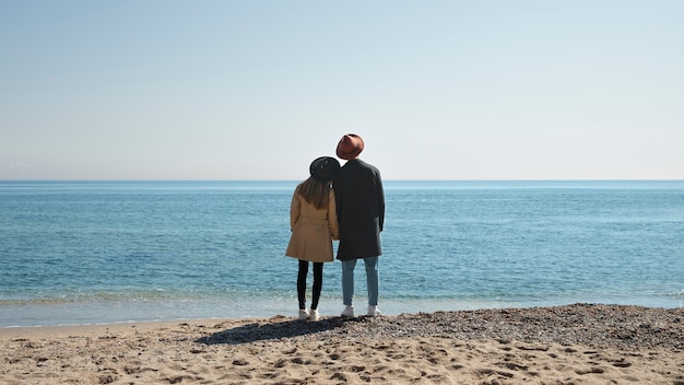 Foto completa de casal romântico à beira-mar