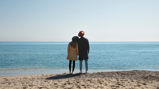 Foto completa de casal romântico à beira-mar