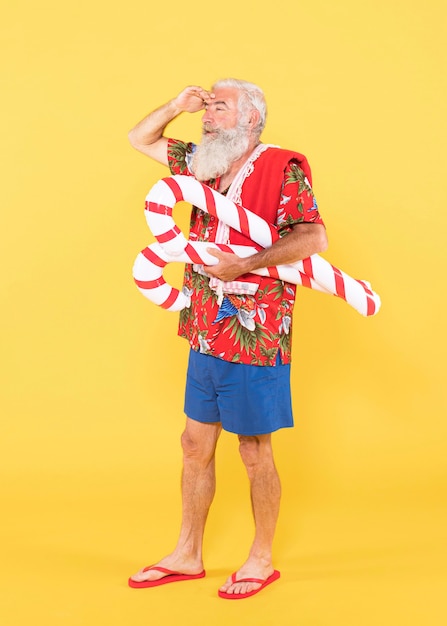 Foto completa de homem com camisa tropical e chapéu de Natal