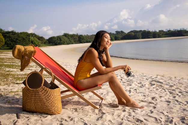 Foto completa de mulher na praia com câmera